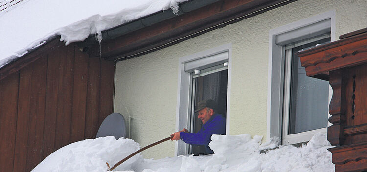 Schnee schippen mal anders: Dieser Anwohner sorgt dafür, dass auch von oben keine Gefahr für Fußgänger besteht.Archiv-Fotos: Die