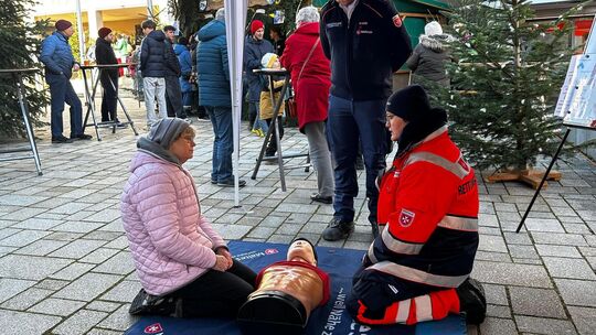 Am Malteser-Stand wird im Weihnachtsambiente gezeigt, wie die Herzdruck-Massage funktioniert. Foto: Jule Störk Am Malteser-Stand wird im Weihnachtsambiente gezeigt, wie die Herzdruck-Massage funktioniert. Foto: Jule Störk