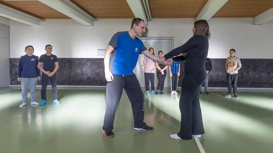 Trainer Frieder Knauss zeigt den Sechstklässlern, wie sie sich aus einem Klammergriff befreien können. Foto: Carsten Riedl Trainer Frieder Knauss zeigt den Sechstklässlern, wie sie sich aus einem Klammergriff befreien können. Foto: Carsten Riedl