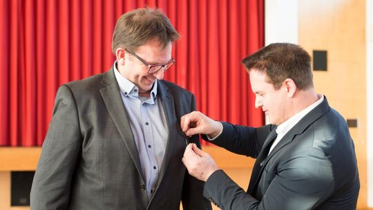 Sven Haumacher, Bürgermeister von Notzingen, steckt Torsten Klein die Ehrennadel des Landes Baden-Württemberg an. Foto: Peter D Sven Haumacher, Bürgermeister von Notzingen, steckt Torsten Klein die Ehrennadel des Landes Baden-Württemberg an. Foto: Peter D