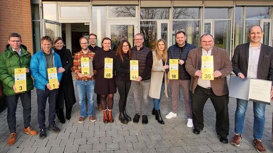 Die Preisträger zeigen stolz die speziellen Hausnummernschilder für ihre prämierten Klimahäuser.  Foto: Elke Hauptmann