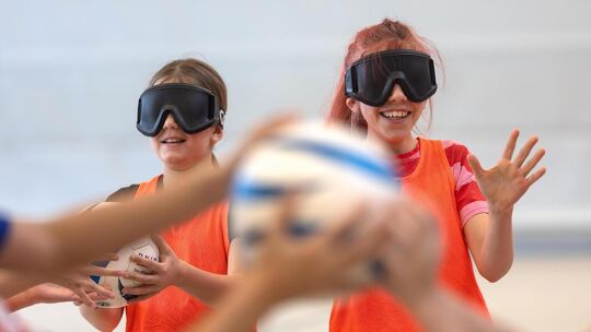 Mit Dunkelbrillen auf der Nase einen rasselnden Blindenfußball herumreichen - nur eine der Aufgaben, die die Fünftklässler der R