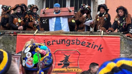 Bürgermeister Michael Schlecht hat sich als Chefarzt verkleidet und trägt eine Schandgeige, um über den schwächelnden Patienten