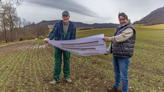 Jörg und Bettina Schmid mit den Bauplänen am Ort, wo einmal ihr neuer Hof stehen soll. Wann das sein wird, weiß im Moment allerd Jörg und Bettina Schmid mit den Bauplänen am Ort, wo einmal ihr neuer Hof stehen soll. Wann das sein wird, weiß im Moment allerd