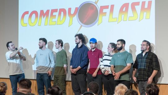 Comedyflash: Der Organisator Dionysis Ghenes (links) mit den sieben Comedians des Abends. Foto: Peter Dietrich