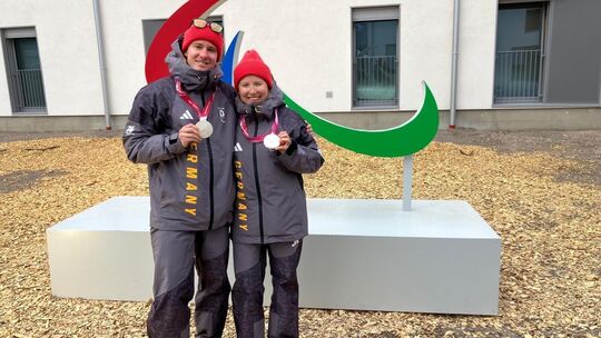 Florian Baumann und Linn Kazmaier zeigen stolz ihre Silbermedaillen, die sie am Dienstag im Langlauf-Sprint gewonnen hatten. Ihr