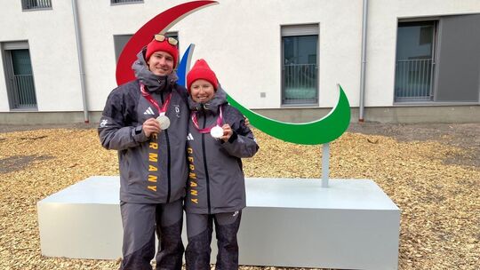 Florian Baumann und Linn Kazmaier zeigen stolz ihre Silbermedaillen, die sie am Dienstag im Langlauf-Sprint gewonnen hatten. Ihr Florian Baumann und Linn Kazmaier zeigen stolz ihre Silbermedaillen, die sie am Dienstag im Langlauf-Sprint gewonnen hatten. Ihr