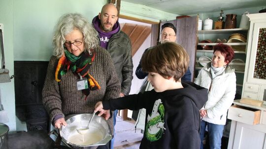 Lenny aus Stuttgart ist zum ersten Mal mit seiner Familie im Freilichtmuseum und darf auch gleich einen Pfannkuchen backen, der