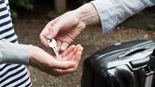 Ein Vermieter übergibt dem Feriengast einen Schlüssel. Symbolfoto: Stock Adobe