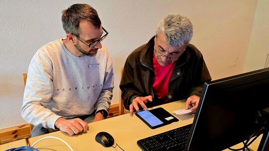 Markus Buck (links) von der Diakonischen Bezirksstelle Kirchheim erklärt Vahap die Nutzung einer App zur Wohnungssuche. Foto: Ka