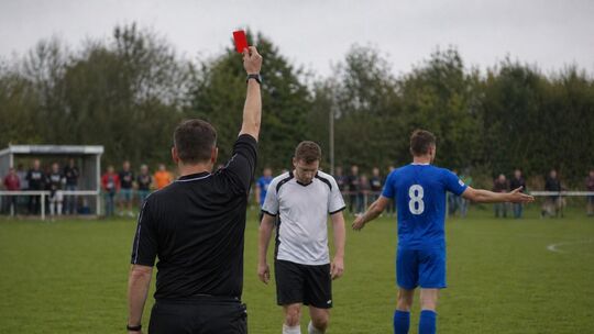 Schiedsrichter stehen auf dem Platz oft alleine da und müssen schwierige Entscheidungen treffen. Symbolfoto: KI-generiert