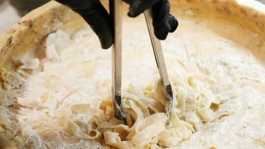 Live-Cooking-Stationen, an denen beispielsweise handgemachte Pasta in einem Parmesanlaib geschwenkt wird, machen das Essen bei e