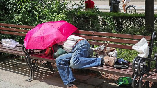 Homeless man is sleeping on a bench in the city Homeless man is sleeping on a bench in the city