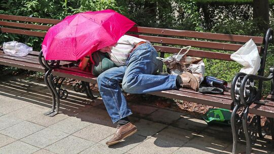 Homeless man is sleeping on a bench in the city Homeless man is sleeping on a bench in the city