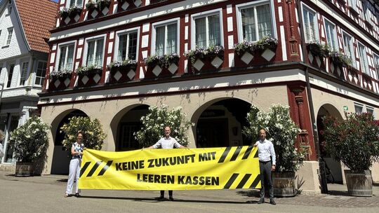 Die Kirchheimer Rathausspitze mit Christine Kullen, Pascal Bader und Achim Rappe zeigt das Mottobanner. Foto: pm Die Kirchheimer Rathausspitze mit Christine Kullen, Pascal Bader und Achim Rappe zeigt das Mottobanner. Foto: pm