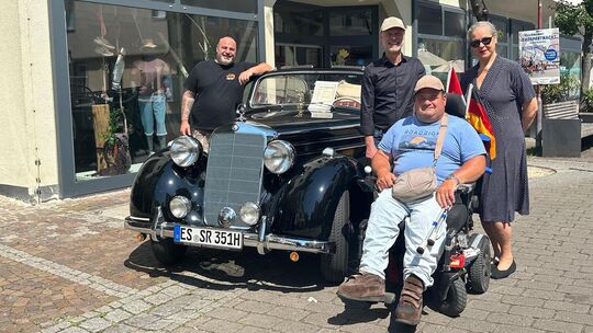 Typisch für das Nachbarschaftsnetzwerk Mittendrin: Für das Foto vor einem historischen Fahrzeug kommt auch ein Bewohner des Quar Typisch für das Nachbarschaftsnetzwerk Mittendrin: Für das Foto vor einem historischen Fahrzeug kommt auch ein Bewohner des Quar