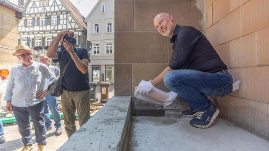 Oberbürgermeister Pascal Bader steckt das Zeitkapsel-Rohr, das zum Schutz vor dem Beton noch zusätzlich in Kunststoff gehüllt is Oberbürgermeister Pascal Bader steckt das Zeitkapsel-Rohr, das zum Schutz vor dem Beton noch zusätzlich in Kunststoff gehüllt is