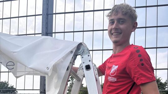 Vorsichtshalber windfest gemacht: Florian Gräter rückt einem Werbebanner zuleibe. Foto: Peter Eidemüller Vorsichtshalber windfest gemacht: Florian Gräter rückt einem Werbebanner zuleibe. Foto: Peter Eidemüller