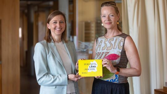 Umweltministerin Thekla Walker (rechts) überreicht Geschäftsführerin Kerstin Leibold eine Auszeichnung für die innovative und na