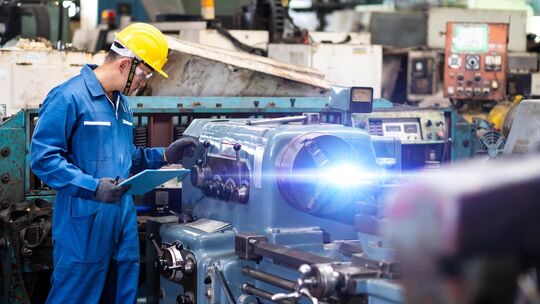 Mechanical Engineering control lathe machine in factory facility. Safety First at work place.