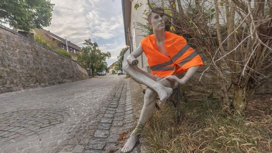 Regungslos bei sengender Hitze, Wind und Wetter sitzt er still an der Hausecke und will den Verkehr im Oberlenninger Ortskern ve