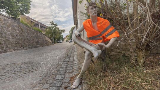 Regungslos bei sengender Hitze, Wind und Wetter sitzt er still an der Hausecke und will den Verkehr im Oberlenninger Ortskern ve Regungslos bei sengender Hitze, Wind und Wetter sitzt er still an der Hausecke und will den Verkehr im Oberlenninger Ortskern ve