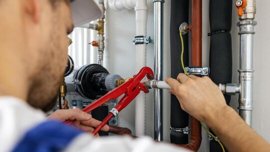 plumber working with pipelines. tighten plumbing fittings plumber working with pipelines. tighten plumbing fittings