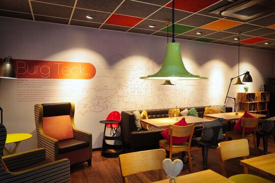 Gemütlicher Café-Sitzbereich mit Wandmotiv der Burg Teck.