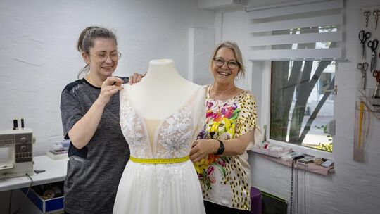 Olga Poliska und Sybille Sommer arbeiten an der Änderung eines Brautkleids. Foto: Carsten Riedl