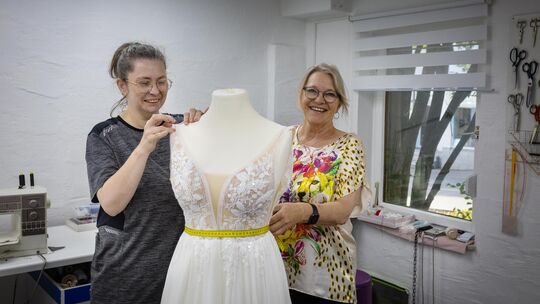Olga Poliska und Sybille Sommer arbeiten an der Änderung eines Brautkleids. Foto: Carsten Riedl