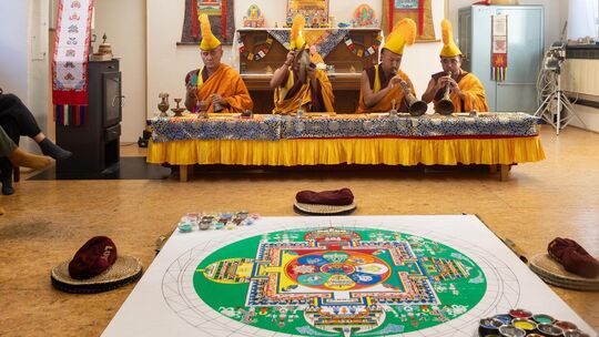 Die buddhistischen Mönche bei der Gebetszeremonie mit Blick auf das Sandmandala. Foto: Carsten Riedl Die buddhistischen Mönche bei der Gebetszeremonie mit Blick auf das Sandmandala. Foto: Carsten Riedl