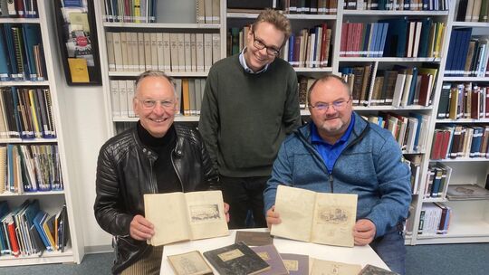 Dieter Hacker (links) und Klaus-Ulrich Lippmann (rechts) präsentieren die 100 Jahre alten Hefte von Wilhelm Vogel, auf die sie b
