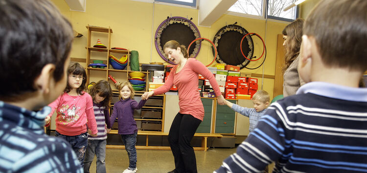 Die Buben und Mädchen im Aichelberg-Kindergarten tanzen mit Musikpädagogin Annegret Kepp (Mitte) im Kreis. Auf spielerische Weis