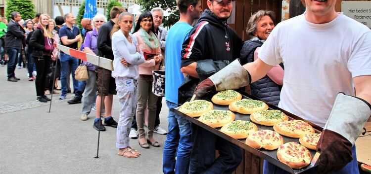 Nachschub aus dem Ofen: Stefan Ringhoffer bringt das nächste Blech voll duftender Dätscher - die Wartenden in der langen ­Schlan