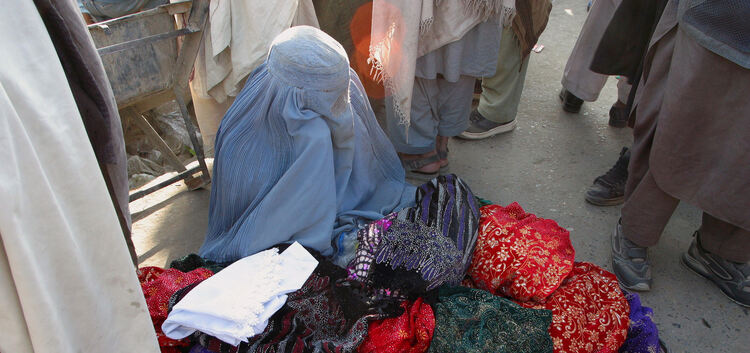 Eine Frau verkauft auf einem afghanischen Markt Stoffe.
