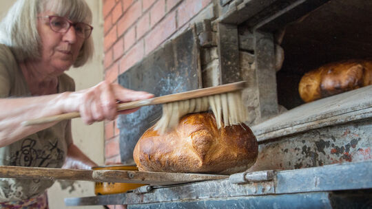 Damit das Brot einen appetitlichen Glanz bekommt, wird es mit Wasser eingerieben und dann noch einmal kurz in den Ofen geschoben