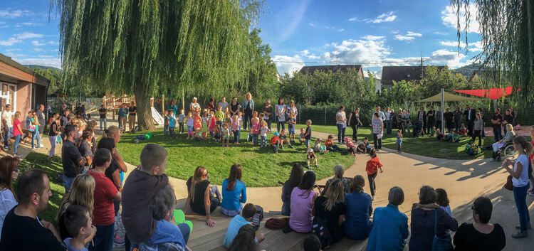 Kinder, Eltern und Großeltern samt Erzieherinnen und den Verantwortlichen der Stadt feiern im neu gestalteten Garten. Fotos: Car