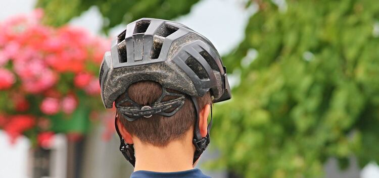 Wer sein Kind mit dem Fahrrad in die Schule schickt, sollte testen, ob der Helm richtig sitzt.