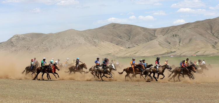 Auf kleinen, zähen Pferden preschen Kinder beim mongolischen Nationalfest durch die Steppe. Schon im Alter von drei Jahren reite