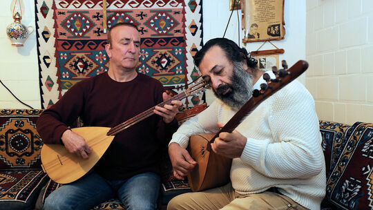 Die türkische Langhalslaute, die auch Baglama genannt wird, hat für Aleviten wie Veysel Aydin (links) und Necmi Öztürk einen zen