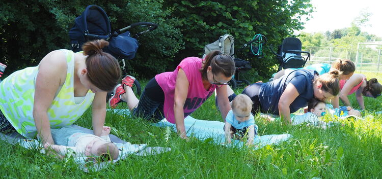 Liegestützen mit Küsschen: Die sportlichen Mamas beziehen ihre Kinder voll in das Work-out mit ein. Janine Wilhelm (unten) leite