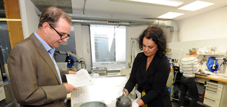 Landesarchäologe Dirk Krausse und Chef-Restauratorin Nicole Ebinger-Rist untersuchen Bronze-Geschirr von einem mittelalterlichen