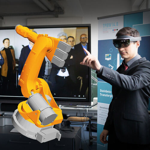 Arbeit am virtuellen Roboter: Ein Mitarbeiter der Hochschule Esslingen erklärt den Gästen in Kirchheim, worum es geht.Foto: Cars
