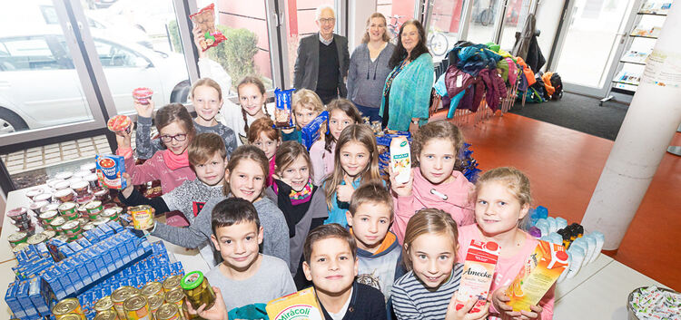 Alles kommt in die Tüte: Kinder aus der Freihof-Grundschule präsentieren die Lebensmittel, die sie anschließend einpacken.Foto: