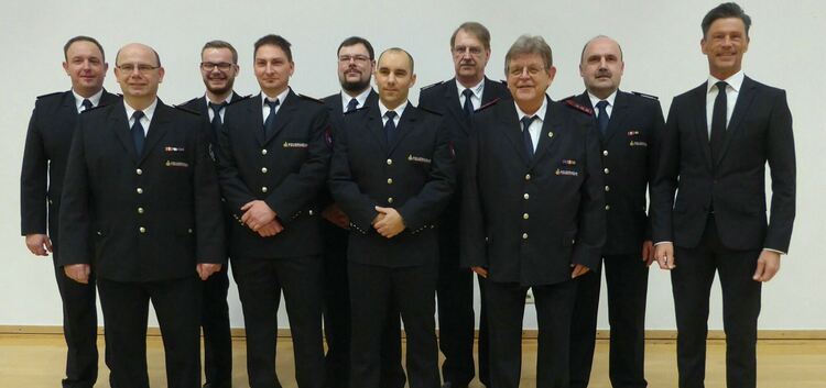 Dettingens Bürgermeister Rainer Haußmann (rechts) mit den geehrten und beförderten Mitgliedern der Feuerwehr.Foto: Walter Wanner