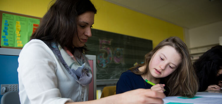 Die Schülerin Tamina, ein Kind mit Downsyndrom, wird im Unterricht von Jessica Spangenberg unterstützt.Foto: dpa