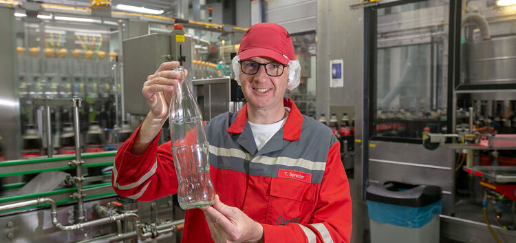 Betriebsleiter Thomas Sprecher zeigt die Ein-Liter-Glasflasche, die nach dem Umbau in Deizisau abgefüllt werden soll. Foto: Robe