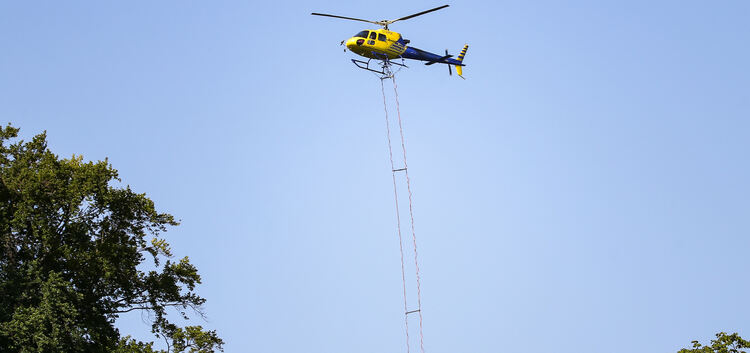 20 Meter unterhalb des Helikopters hängt der Stahlkübel. Foto: Tom Weller