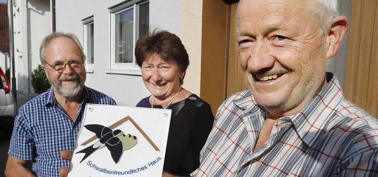 Heinz Schöttner vom Naturschutzbund Dettingen (links) überreicht dem Ehepaar Klein die Auszeichnung „Schwalbenfreundliches Haus“