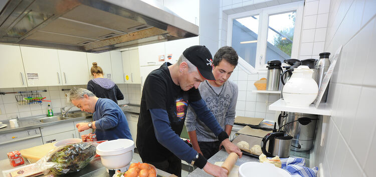 Vorbereitungen fürs Abendessen: Vincent Wölke (rechts) zeigt Ralf, wie man den Teig ausrollt. Foto: Deniz Calagan